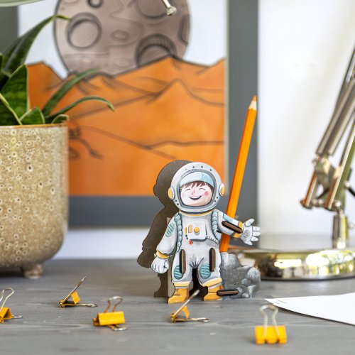 Astronautin Nora hält einen Stift griffbereit auf dem Schreibtisch