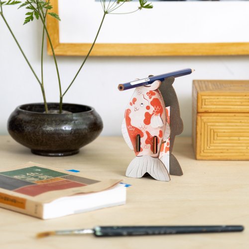 Koi Yoko hält einen Stift griffbereit auf dem Schreibtisch