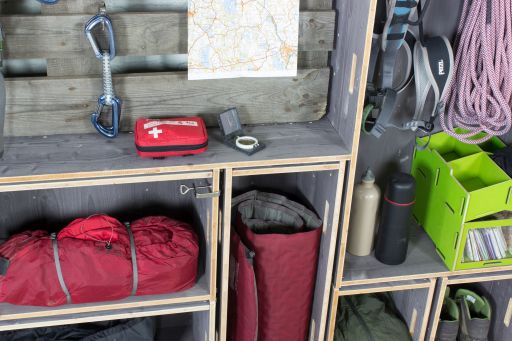 Camping-Equipment im offenen Wandregal