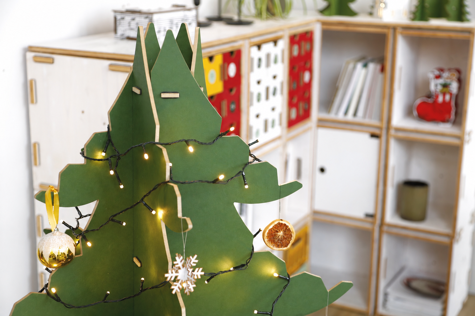 Spitze des gr&uuml;nen WERKHAUS Steck-Weihnachtsbaums aus ineinandergesteckten MDF-Elementen, dekoriert mit einer Lichterkette.